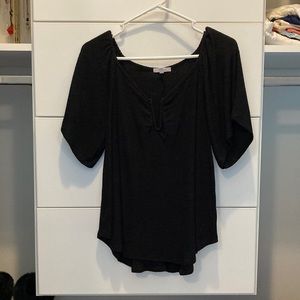 Black short sleeve blouse that has a “v” in the middle